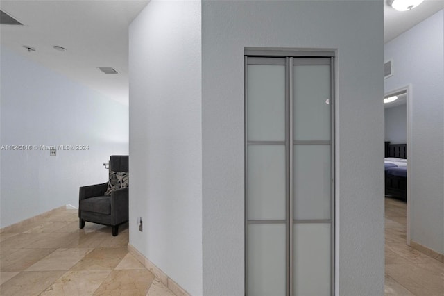 hallway featuring visible vents and baseboards