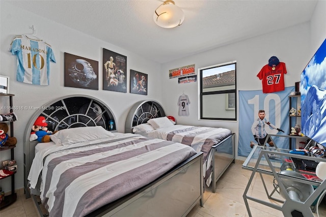 bedroom featuring a textured ceiling and light tile patterned flooring