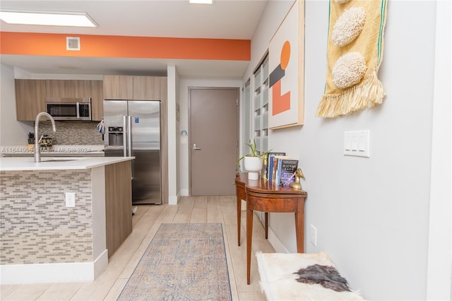 kitchen featuring tasteful backsplash, appliances with stainless steel finishes, and a kitchen breakfast bar