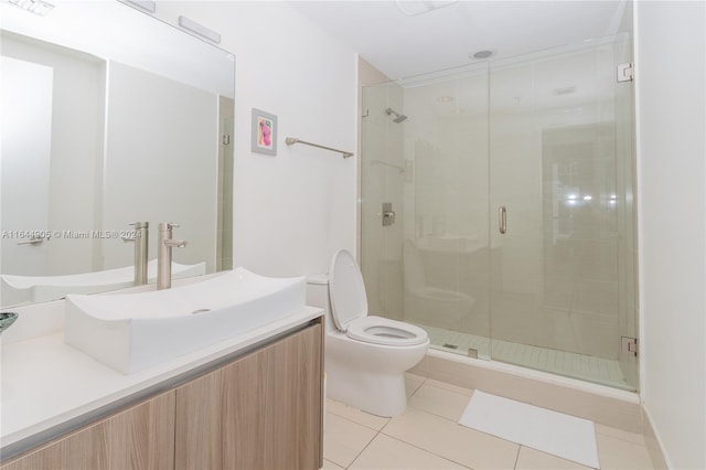 bathroom featuring vanity, toilet, tile patterned floors, and a shower with door