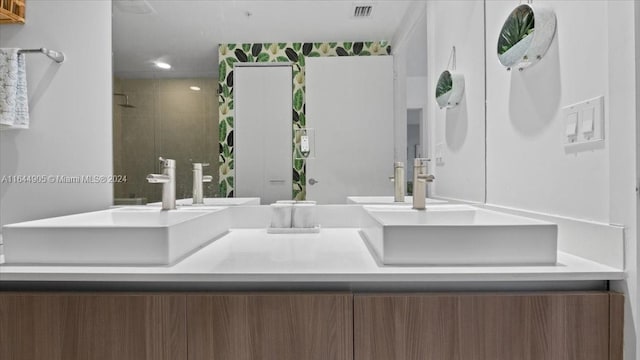 bathroom with vanity and a tile shower