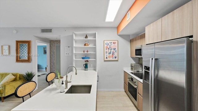 kitchen with light brown cabinetry, appliances with stainless steel finishes, and sink