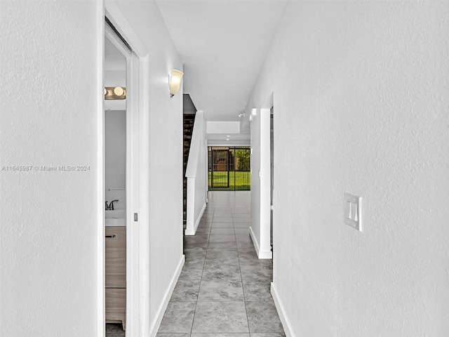 hallway with sink and tile patterned floors