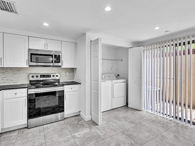 kitchen with washing machine and clothes dryer, white cabinetry, a healthy amount of sunlight, and stainless steel appliances