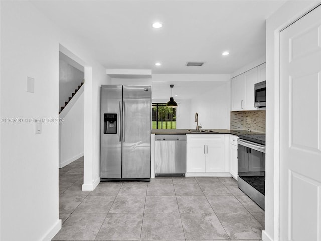 kitchen with sink, hanging light fixtures, appliances with stainless steel finishes, and light tile patterned floors