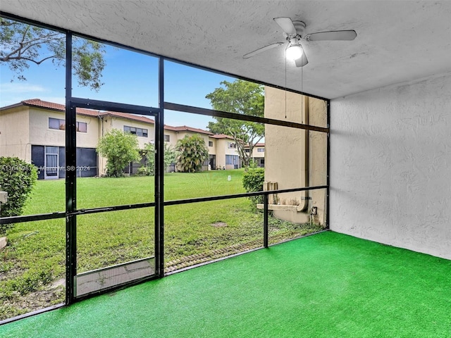 unfurnished sunroom with ceiling fan