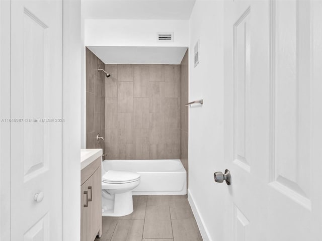 full bathroom with tile patterned floors, vanity, tiled shower / bath combo, and toilet