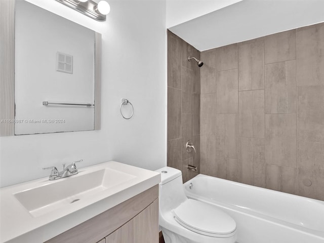 full bathroom featuring toilet, tiled shower / bath, and vanity