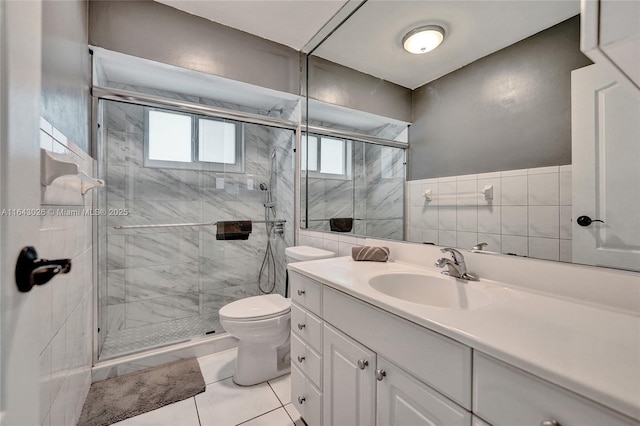 bathroom with vanity, tile patterned floors, toilet, tile walls, and an enclosed shower