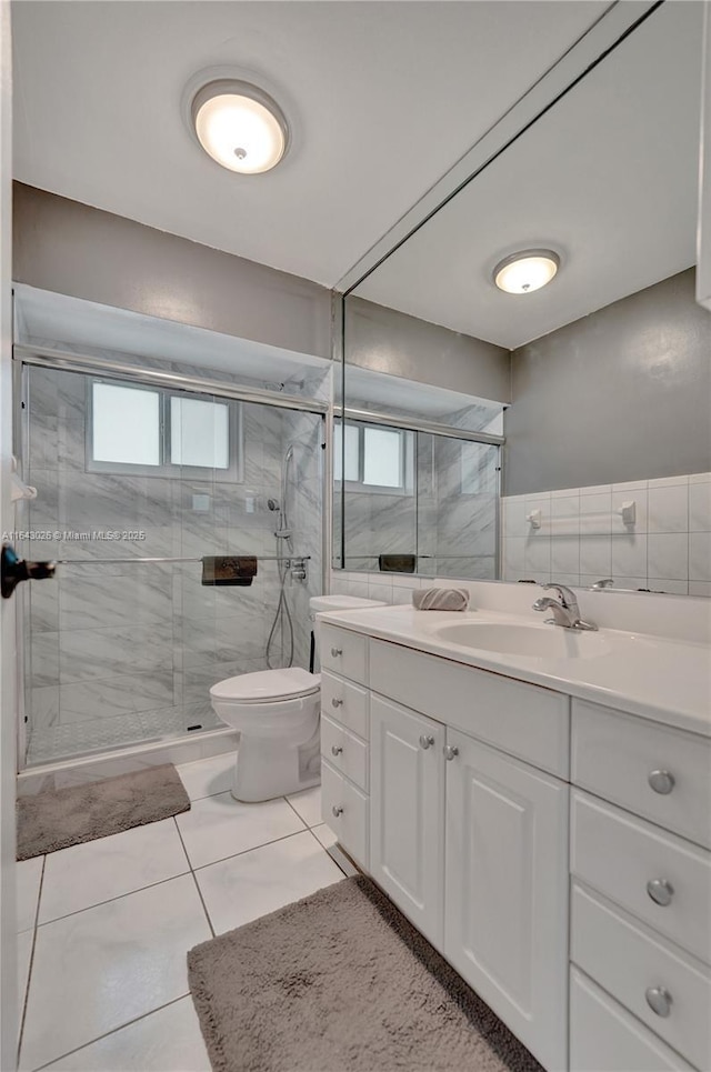 bathroom featuring an enclosed shower, vanity, tile walls, tile patterned flooring, and toilet