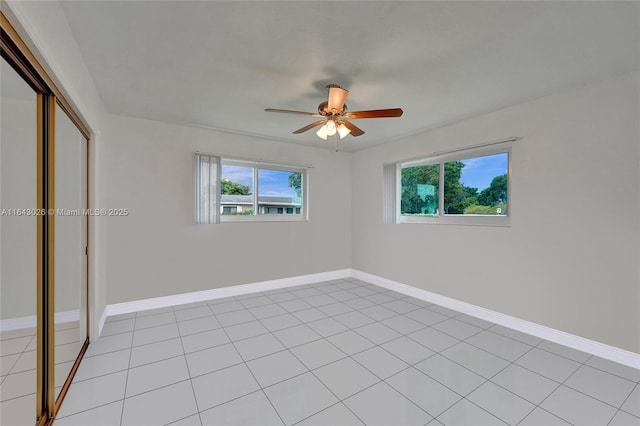 unfurnished bedroom featuring ceiling fan, a closet, and light tile patterned floors