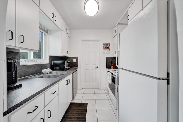 kitchen with decorative backsplash, white appliances, sink, light tile patterned floors, and white cabinets