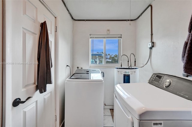 laundry room featuring separate washer and dryer and light tile patterned floors