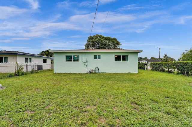 back of house featuring a lawn