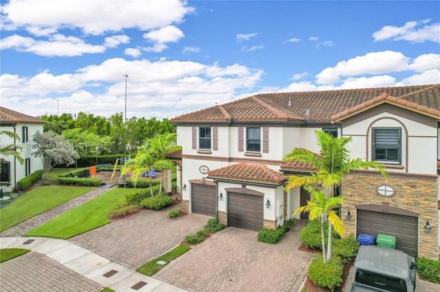 mediterranean / spanish home with a garage and a front yard