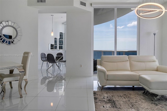 living room with a water view, an inviting chandelier, and light tile patterned floors