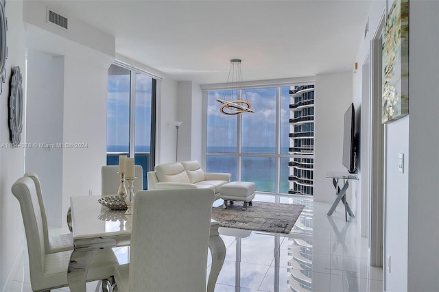 dining area featuring a wall of windows, a chandelier, and light tile patterned floors