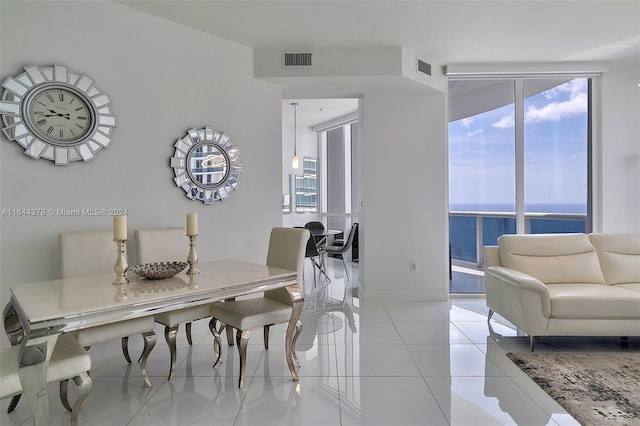 tiled dining space featuring a water view and a wealth of natural light