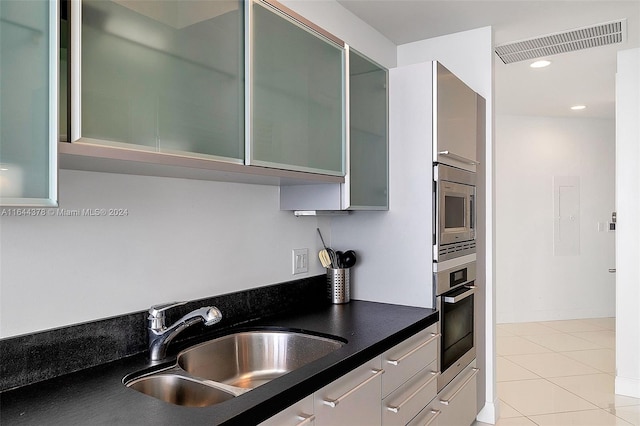 kitchen featuring light tile patterned floors, stainless steel appliances, and sink