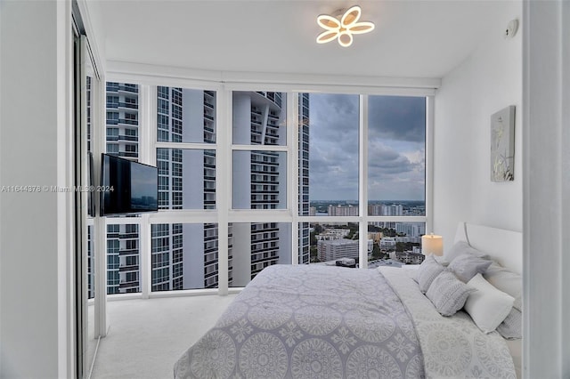 bedroom featuring expansive windows and carpet floors