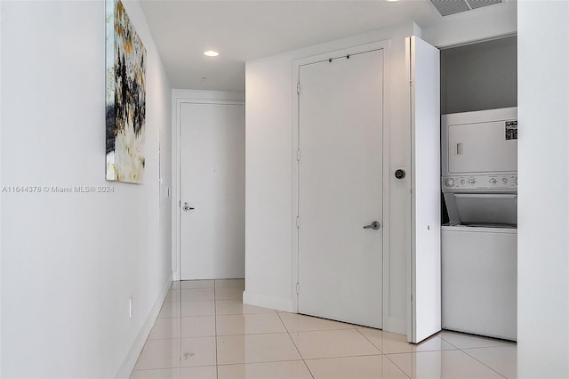 interior space with stacked washer / drying machine and light tile patterned floors