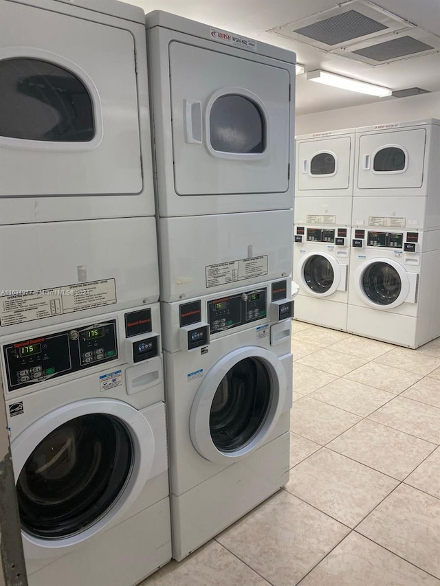 shared laundry featuring stacked washer and clothes dryer, washing machine and clothes dryer, and light tile patterned floors