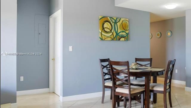 dining space featuring light tile patterned floors and baseboards