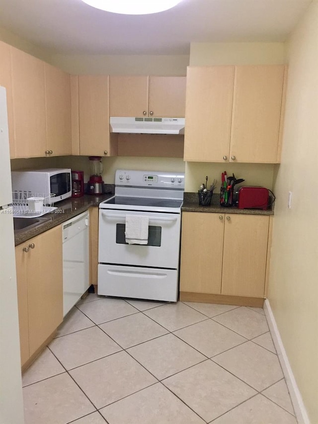 kitchen with light brown cabinetry, white appliances, under cabinet range hood, and light tile patterned floors