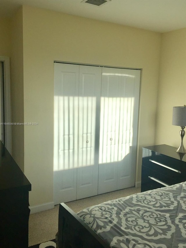 bedroom with baseboards, visible vents, and light colored carpet