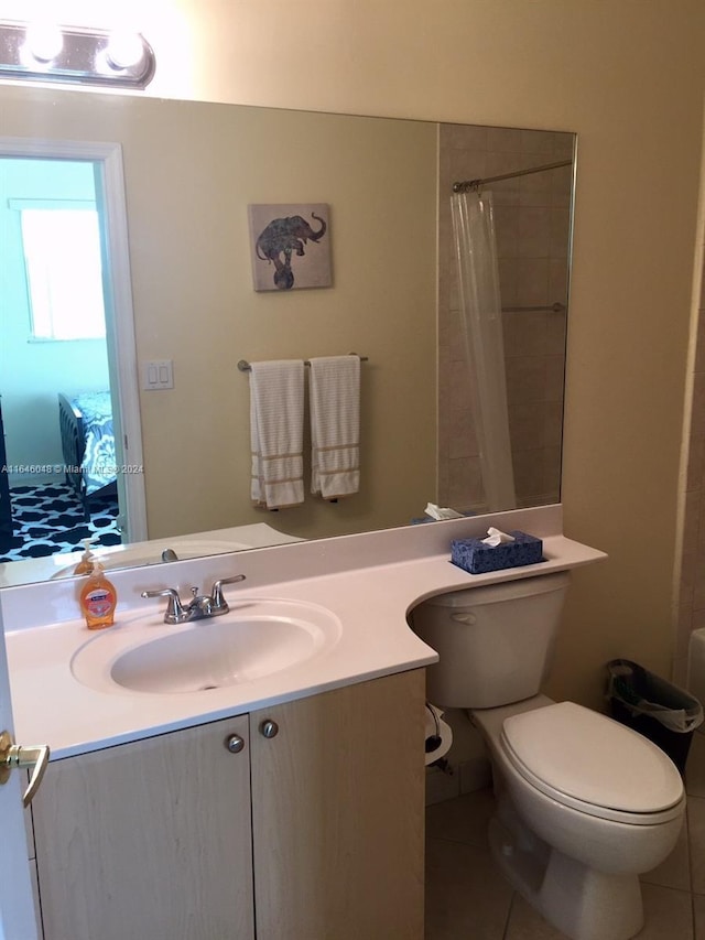 ensuite bathroom with toilet, connected bathroom, vanity, tiled shower, and tile patterned floors