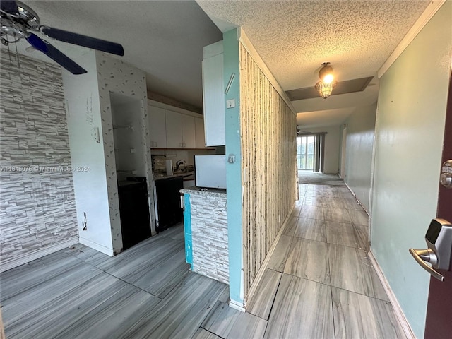 corridor with a textured ceiling and light tile patterned floors