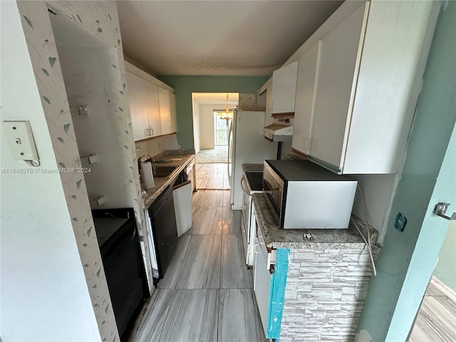 kitchen featuring black dishwasher, sink, light wood-type flooring, premium range hood, and white cabinets