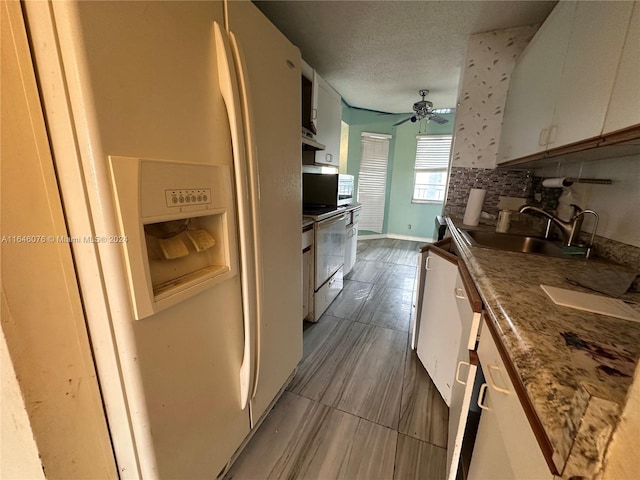 kitchen with decorative backsplash, white cabinetry, sink, white fridge with ice dispenser, and ceiling fan