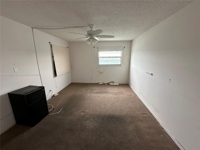 unfurnished room with ceiling fan, a textured ceiling, and carpet floors