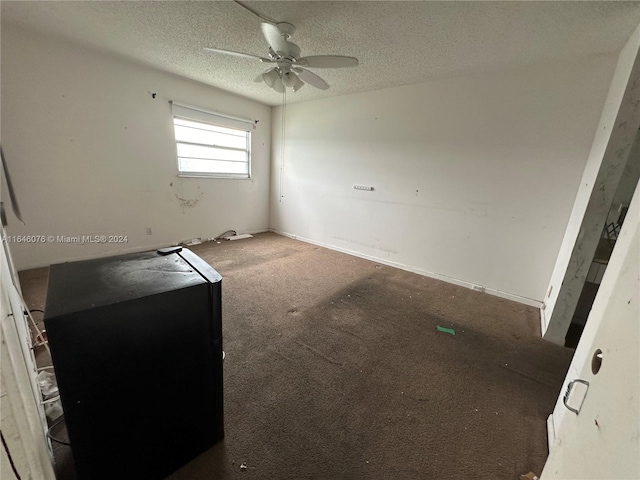 carpeted spare room featuring a textured ceiling and ceiling fan