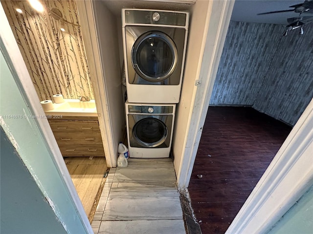 laundry room with stacked washer / drying machine and hardwood / wood-style flooring