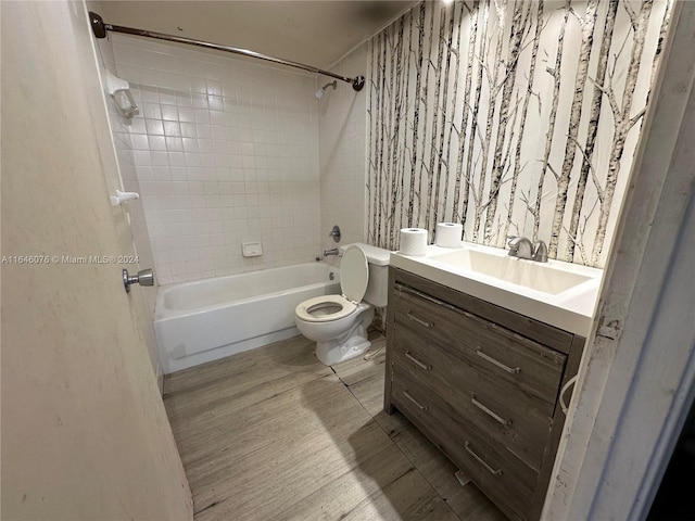 full bathroom featuring toilet, tiled shower / bath, vanity, and wood-type flooring