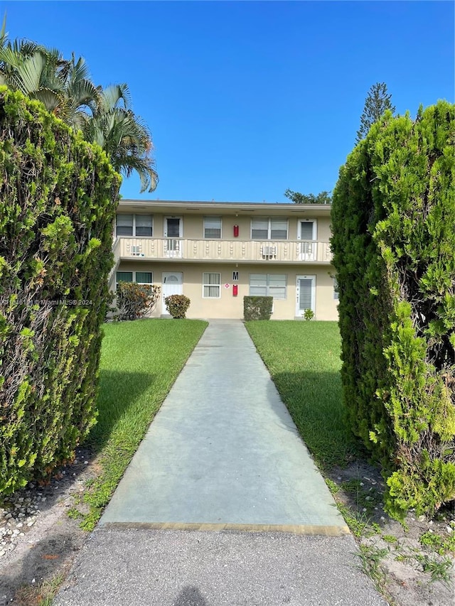 view of front of home featuring a balcony and a front yard