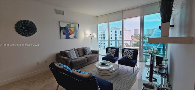 living area with a wall of windows, a city view, visible vents, and baseboards