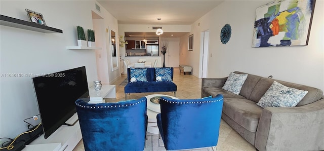 living room with baseboards, visible vents, a fireplace with raised hearth, and tile patterned floors