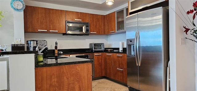 kitchen featuring dark stone countertops, sink, and appliances with stainless steel finishes