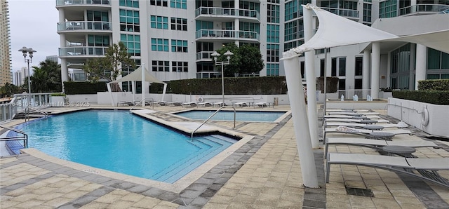 community pool featuring a patio and fence