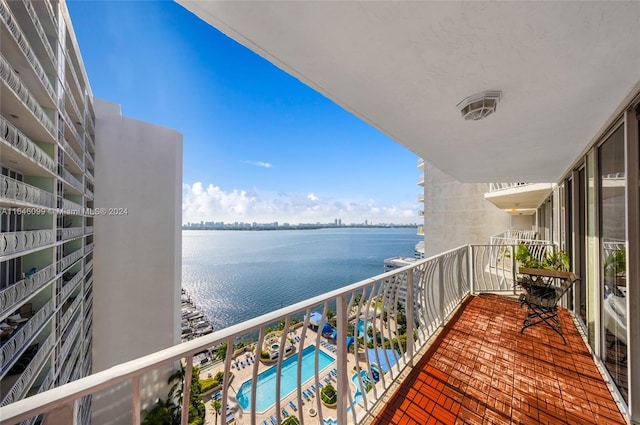 balcony with a community pool and a water view