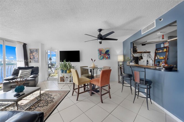 dining space featuring a textured ceiling, ceiling fan, and tile patterned floors