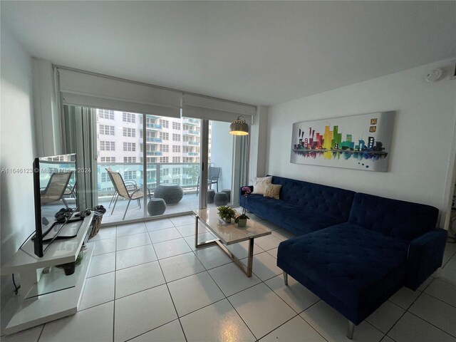 tiled living room featuring floor to ceiling windows