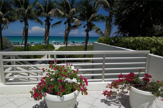 balcony featuring a beach view and a water view