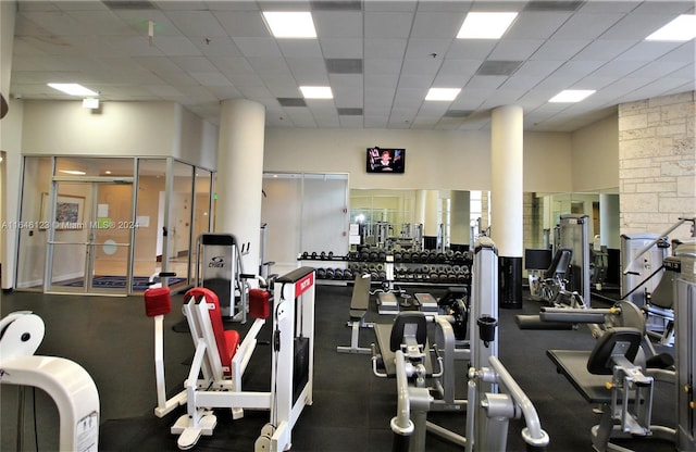 workout area with a drop ceiling and a towering ceiling