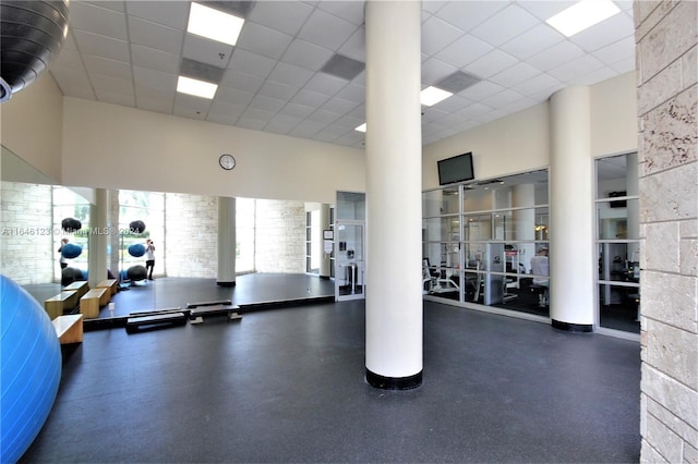 exercise room with a high ceiling and a paneled ceiling