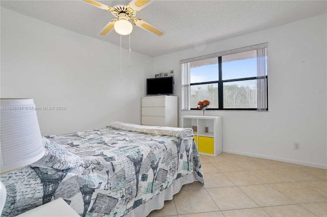 tiled bedroom with ceiling fan and a textured ceiling