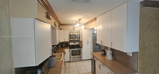 kitchen with white cabinetry, appliances with stainless steel finishes, sink, and light tile patterned flooring